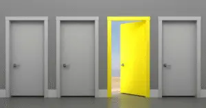 Bright yellow open door leading to a beach among closed gray doors representing opportunity