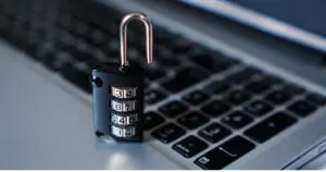 Open combination padlock on a laptop keyboard representing digital security