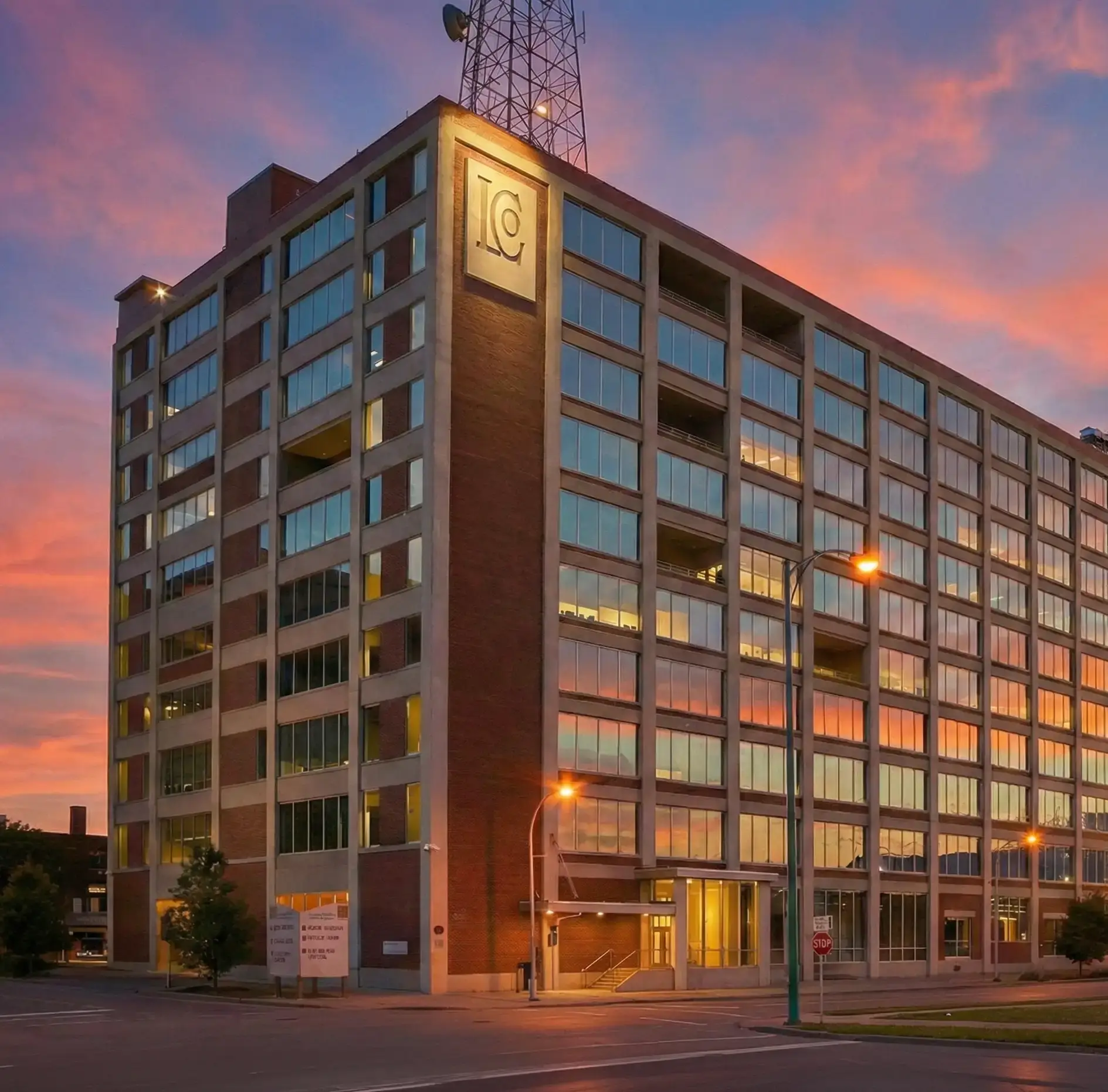 Modern brick commercial building with LC logo under a vibrant sunset sky