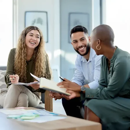 Diverse colleagues smiling and collaborating during a business meeting in a modern office